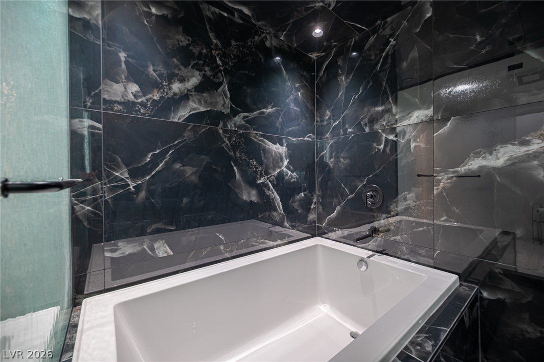 3139 Regal Oak Drive, Henderson, NV 89014 Dramatic dark marble surrounds a deep soaking tub in this contemporary master bath.