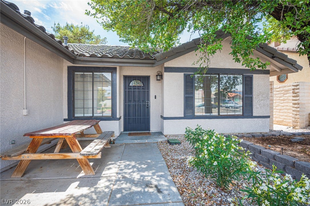 3139 Regal Oak Drive, Henderson, NV 89014 Mature trees shade a welcoming front entrance with stucco exterior and tile roofing.