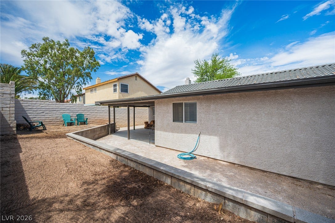 3139 Regal Oak Drive, Henderson, NV 89014 A concrete patio extends along the stucco exterior beneath a tiled roofline.