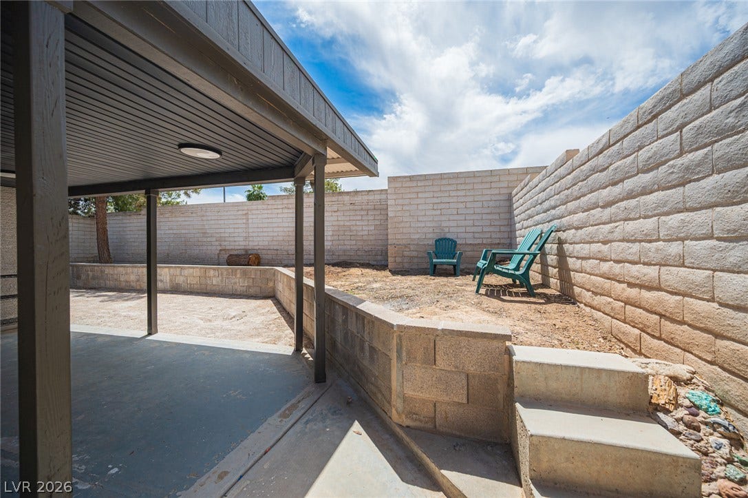 3139 Regal Oak Drive, Henderson, NV 89014 Multi-level concrete patio surfaces lead to an elevated back yard framed by block retaining walls.