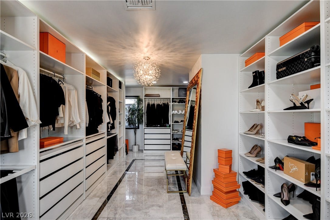 Polished tile flooring and custom built-in shelving define this custom walk-in closet space.