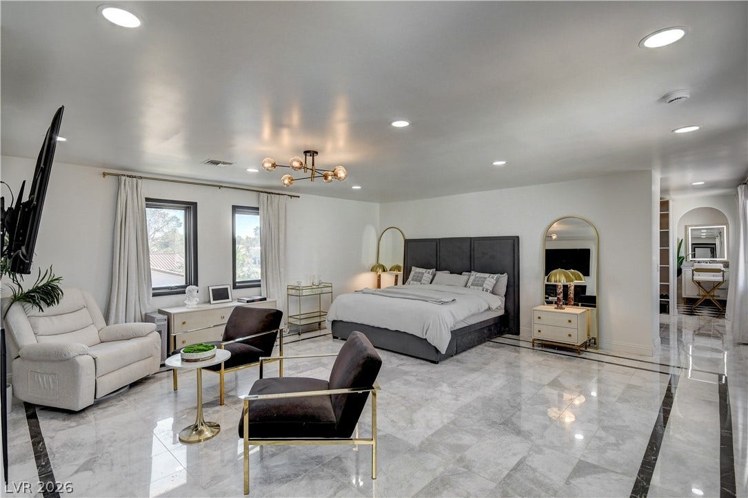 Polished tile flooring and recessed lighting define this spacious bedroom suite.