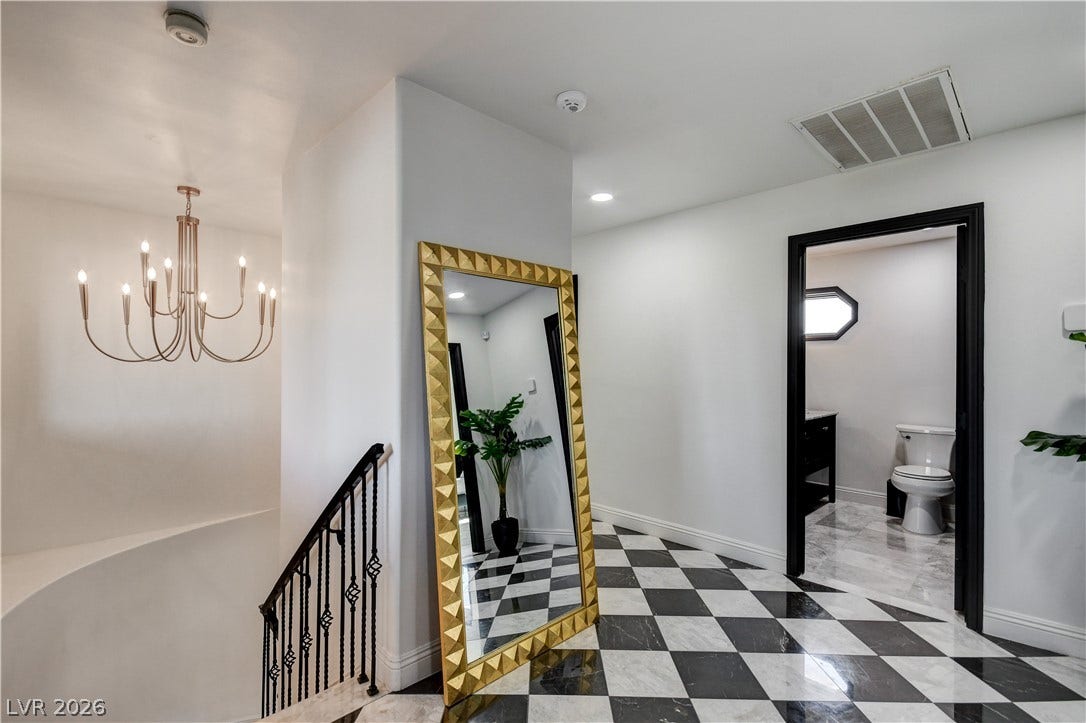 Geometric tile flooring creates a classic design foundation in this well-appointed upper hallway.