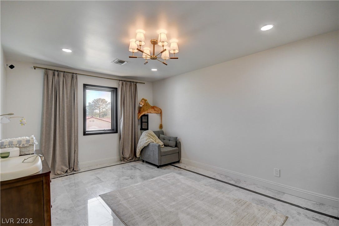 Polished tile flooring and recessed lighting define this versatile secondary bedroom space.