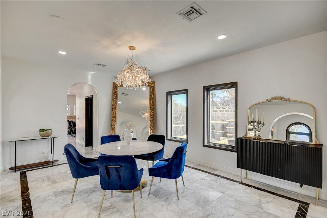 Gleaming marble flooring and an elegant arched doorway define this inviting dining room space.