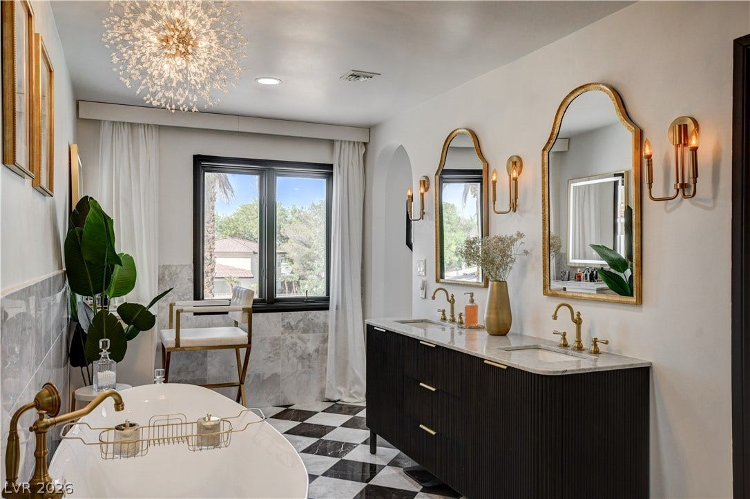 Ornate gold fixtures and a patterned tile floor elevate this modern bathroom design.