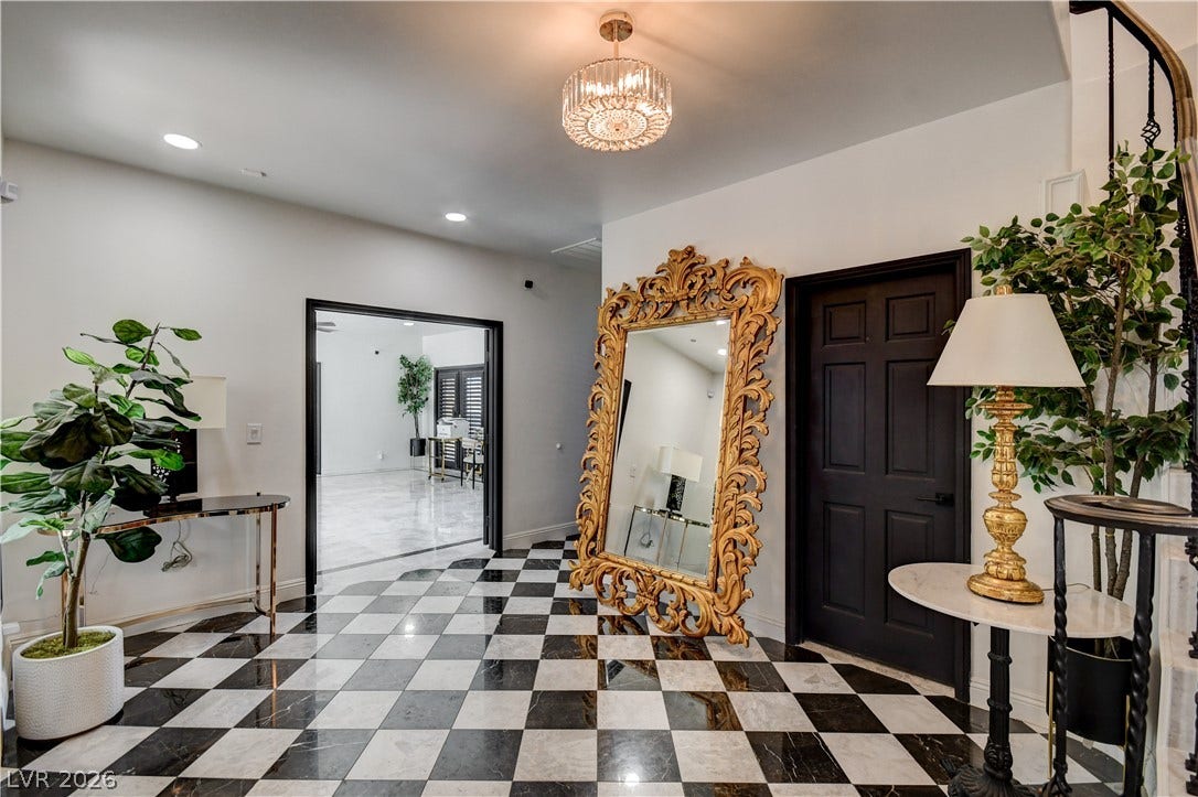 Checkerboard tile flooring and an elegant light fixture define this welcoming entryway.