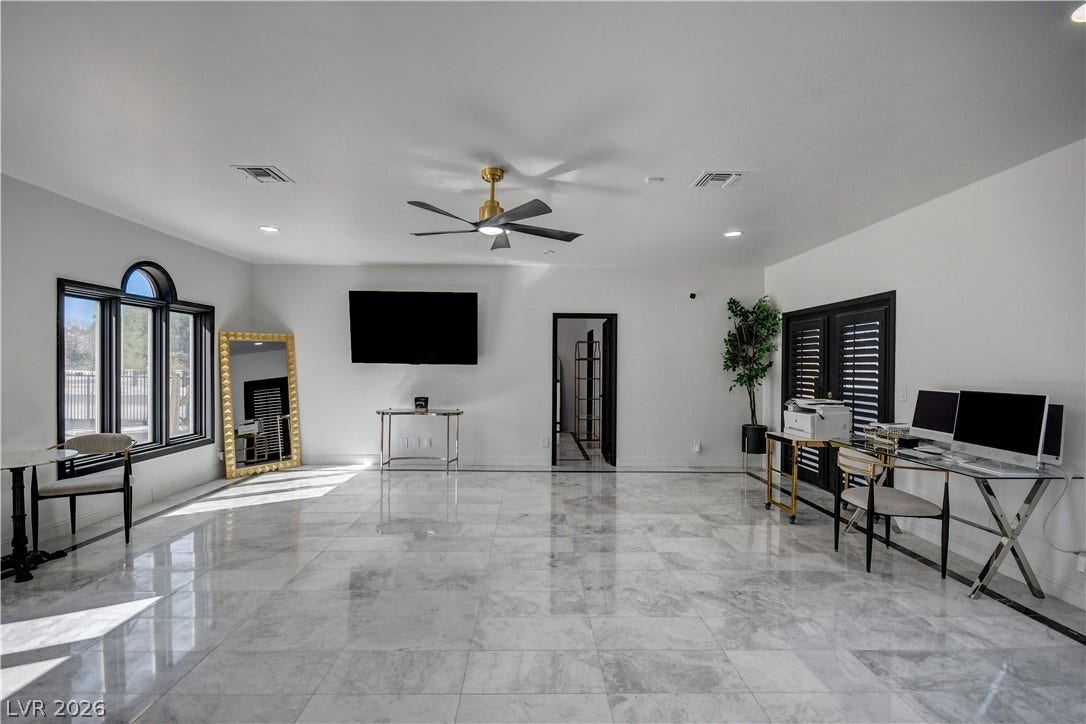 Polished tile flooring and an arched window define this versatile interior space.