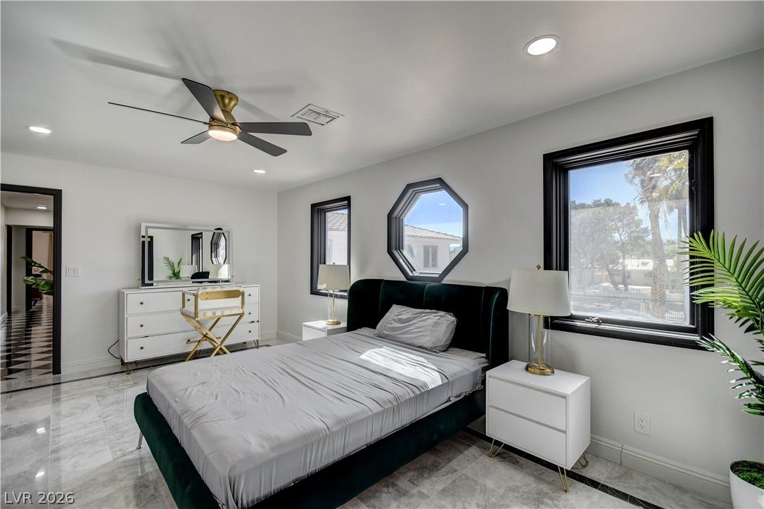 Polished tile flooring and distinctive custom windows define this light-filled modern bedroom.