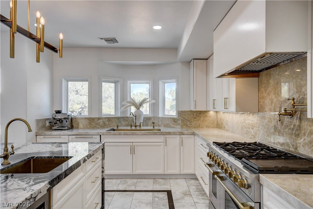 Polished stone counters, custom cabinetry, and premium appliances define this elegant kitchen space.