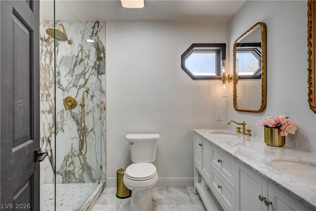 Gleaming marble counters and a tiled walk-in shower elevate this updated master bathroom.