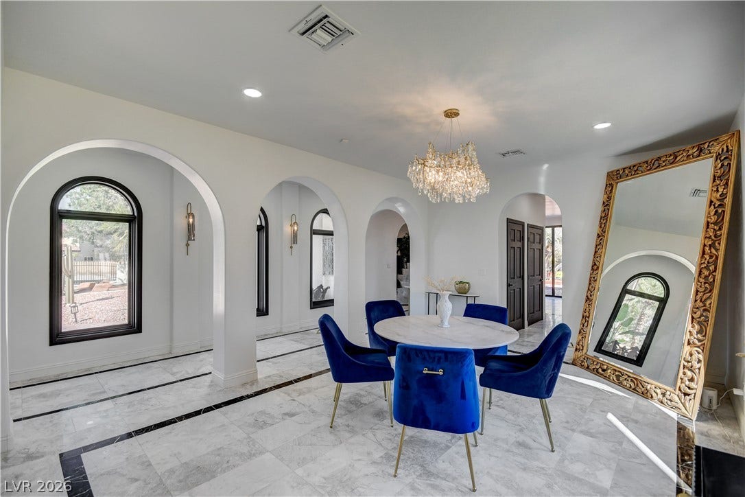 Elegant arched entryways, smooth marble tile flooring, and clean white walls define this refined space.