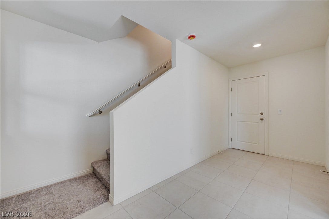 Clean tile flooring transitions to carpeted stairs in this welcoming entry space.