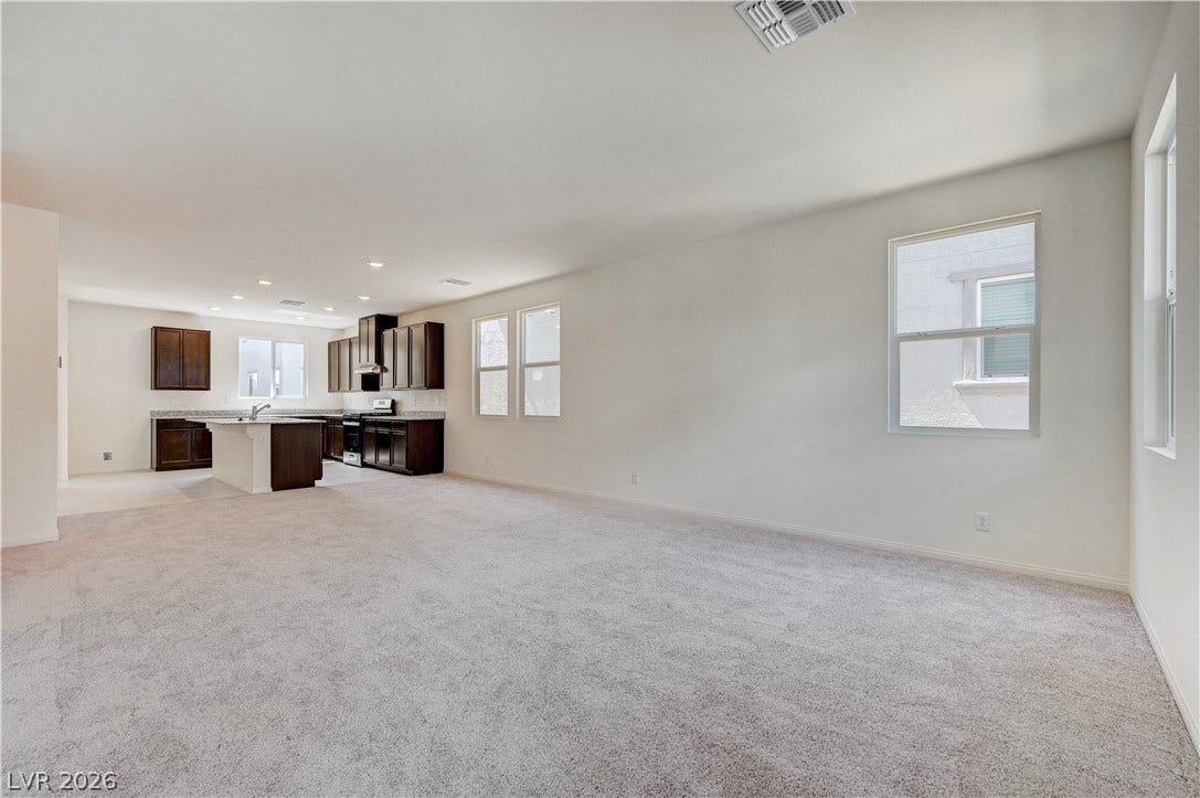 Plush carpeting and abundant natural light define this versatile open living space.