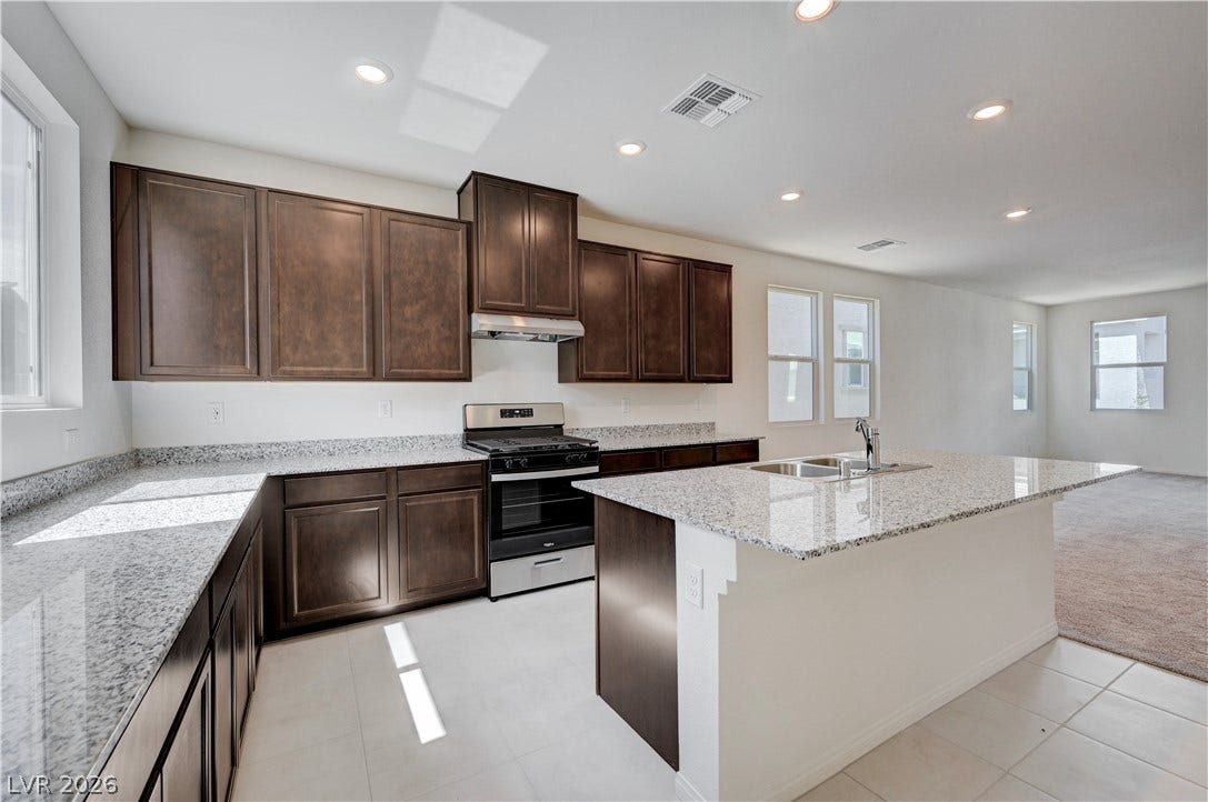 Rich wood cabinetry contrasts beautifully with granite countertops in this open concept kitchen design.