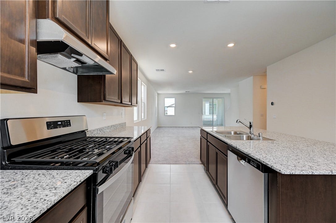 Rich wood cabinetry contrasts beautifully with granite countertops in this open concept kitchen design.