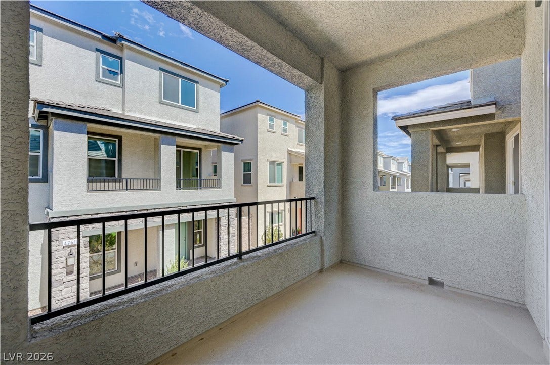 An elevated covered balcony provides a private outdoor retreat overlooking the neighboring community.