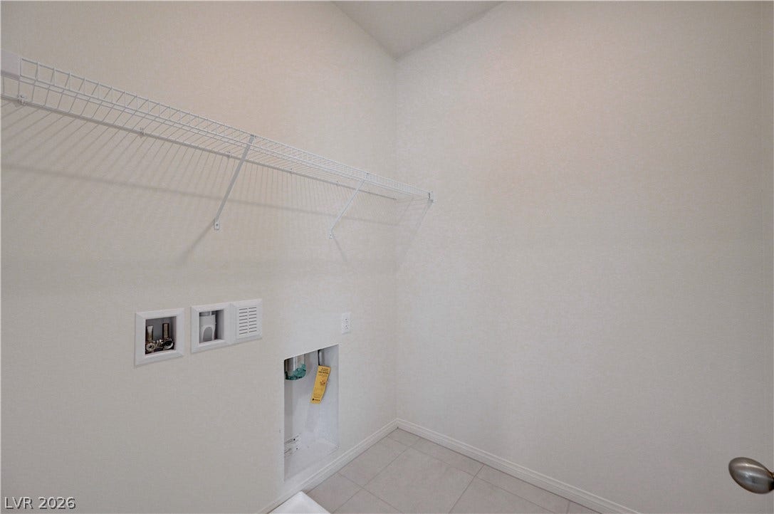 Tiled flooring and convenient built-in shelving define this utility area.