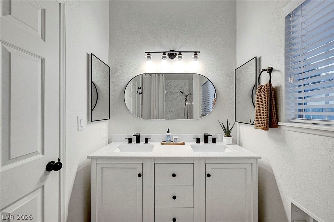Clean lines and a dual sink vanity define this contemporary restroom space.