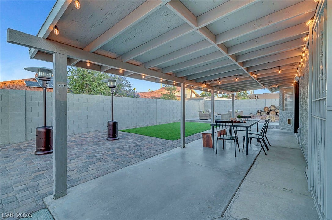 Sheltered outdoor living transitions seamlessly to a private yard lined with secure block fencing.