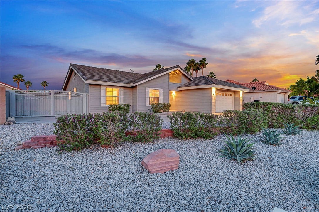 Desert landscaping and a gated side yard frame this classic single-story home at sunset.