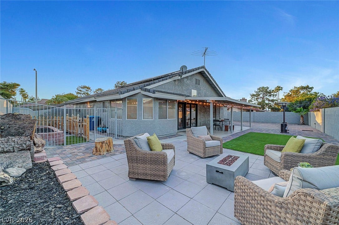 A spacious stone patio and covered terrace provide abundant outdoor living space.