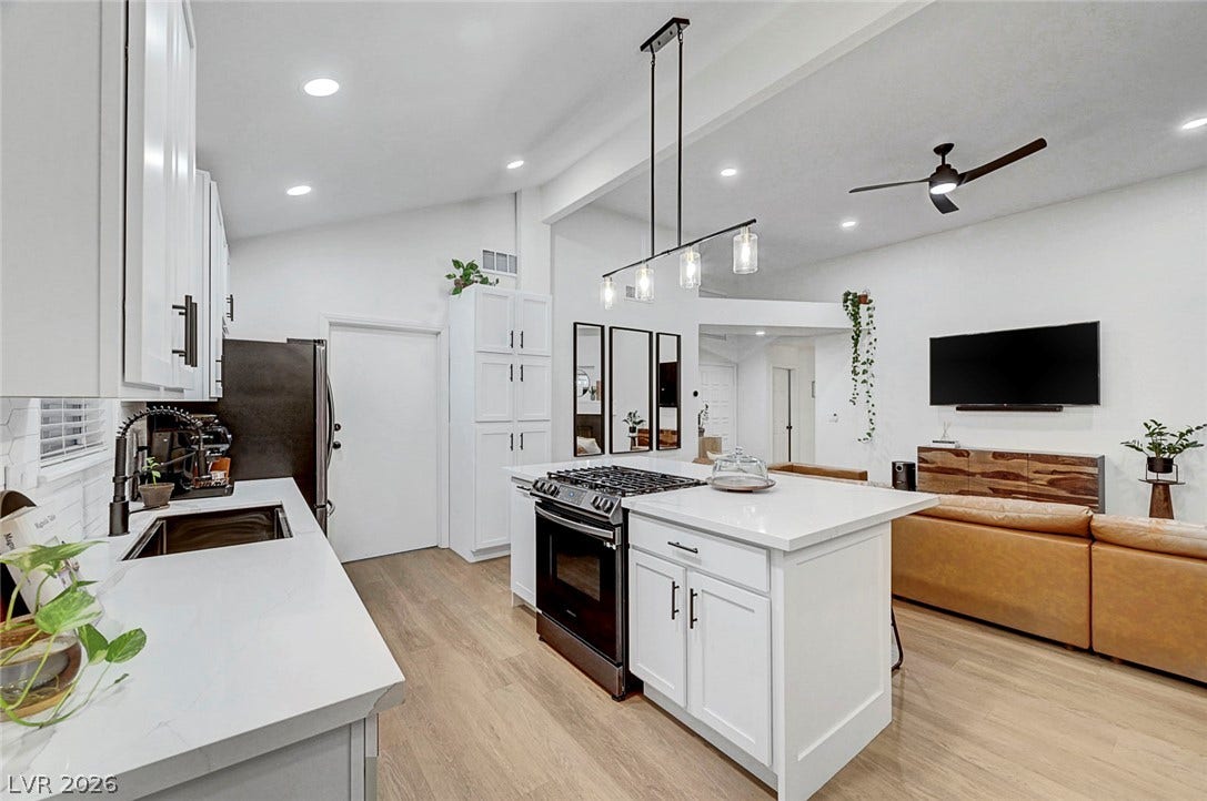 Gleaming stone countertops and a central island ground this light-filled culinary workspace.