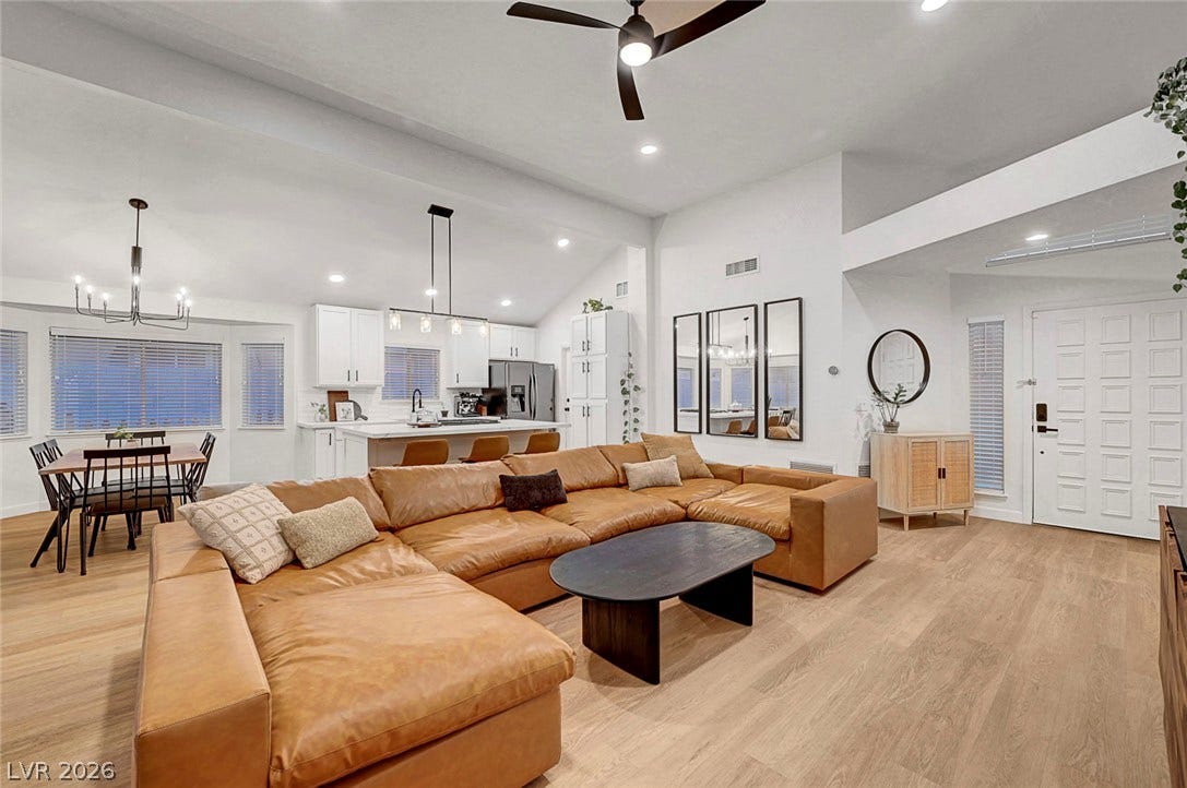 Vaulted ceilings and warm wood floors define this welcoming open-concept living space.