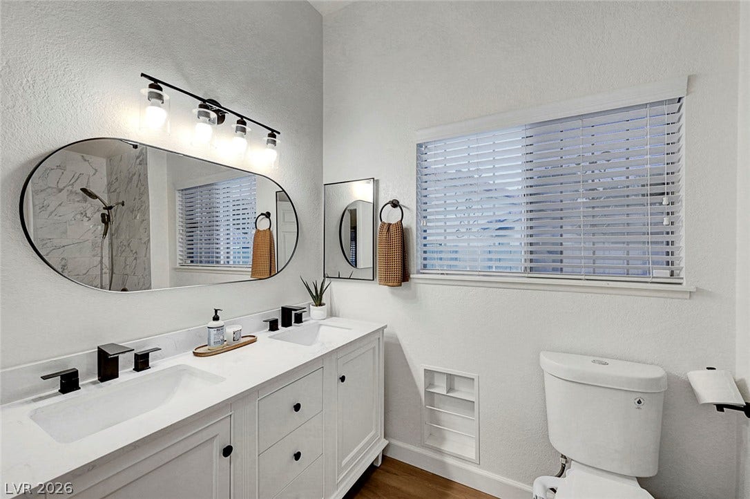 A spacious vanity with dual sinks anchors this well-appointed bathroom.