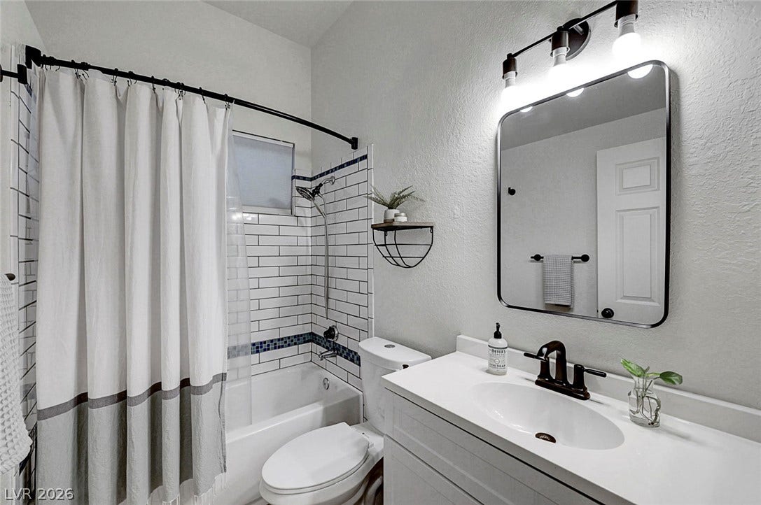 Modern finishes define this refreshed bathroom complete with subway tiling and a sleek vanity.