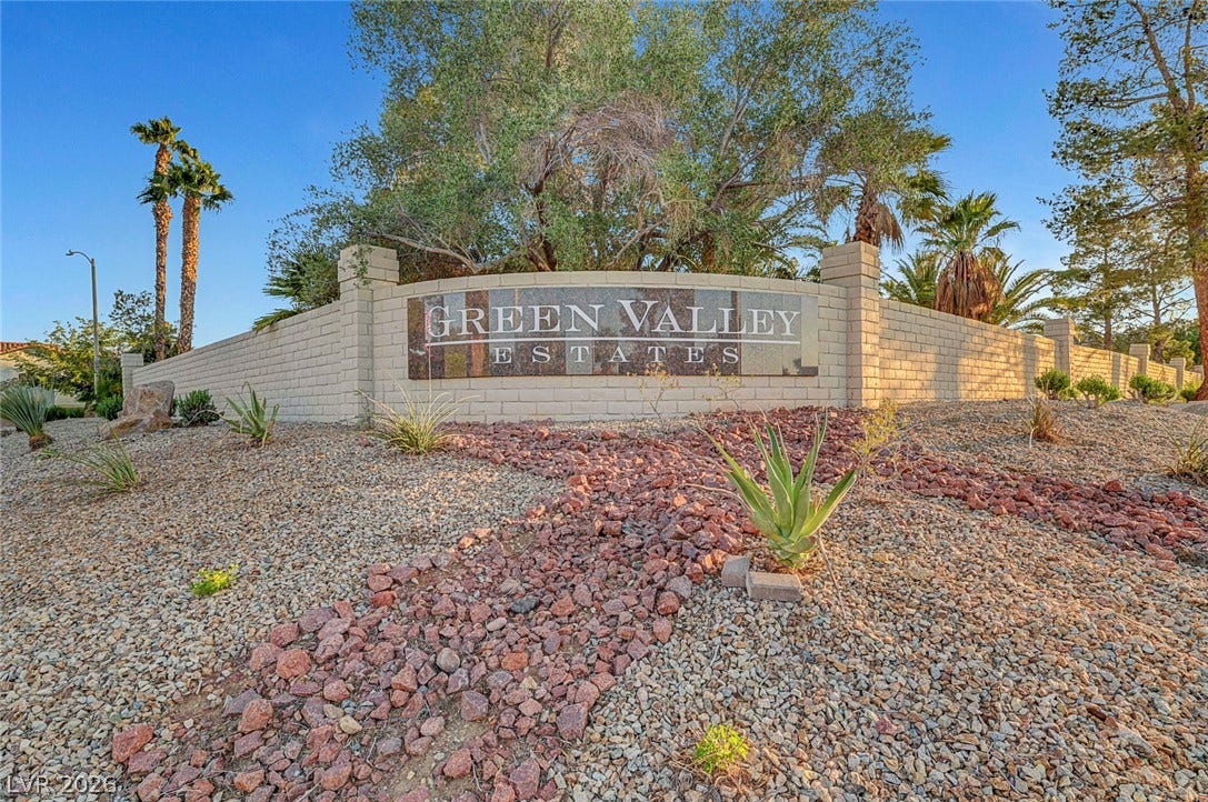 A stone monument sign marks the gated entrance of this established neighborhood.