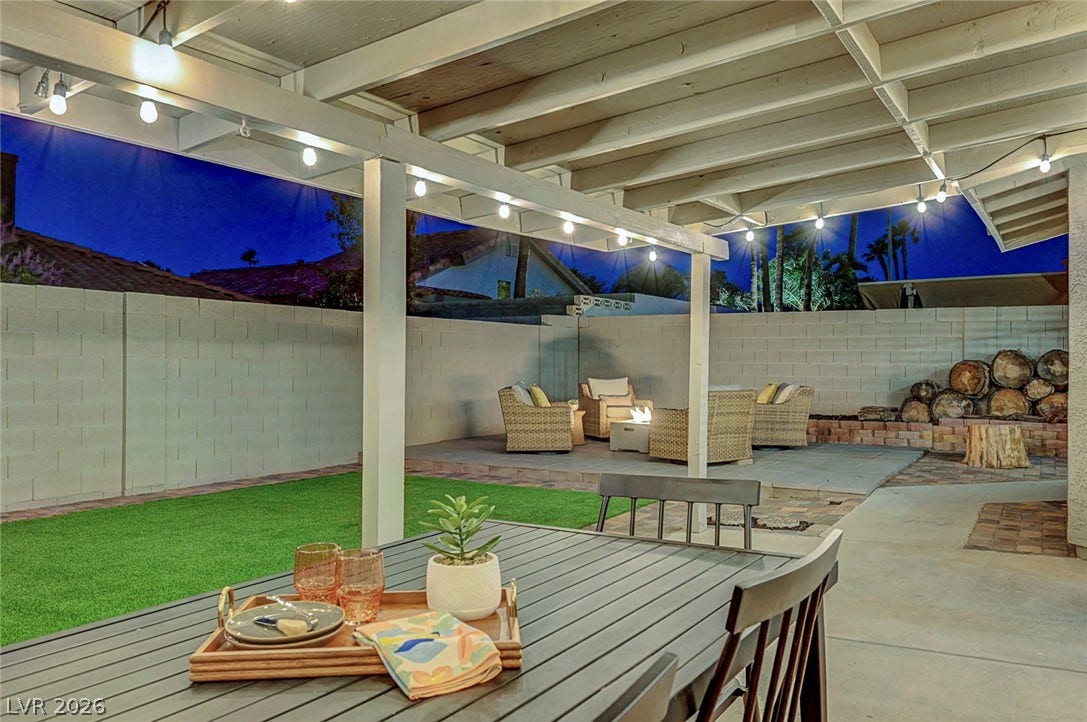 An inviting covered patio opens to a walled backyard perfect for evening gatherings.