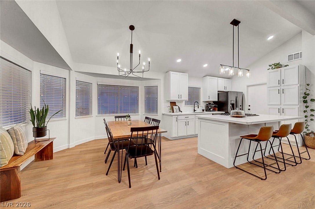Angled windows and vaulted ceilings bring character to this airy open-concept kitchen and dining layout.