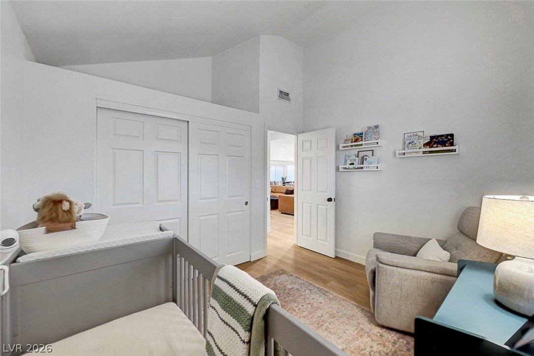 High vaulted ceilings and rich wood floors create a serene, airy atmosphere in this bedroom.