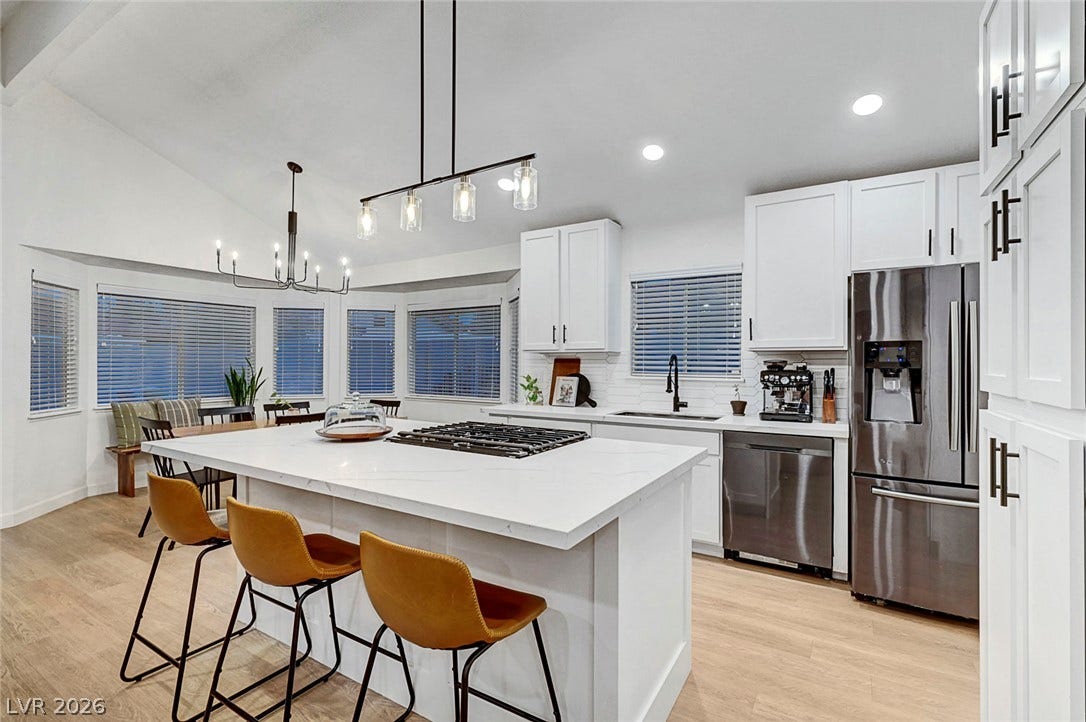 Gleaming stone countertops and stainless steel appliances anchor this light-filled culinary workspace.