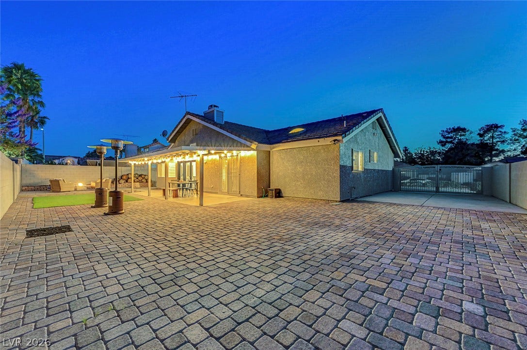 Expansive paver courtyard leads to a covered patio perfect for evening outdoor dining.