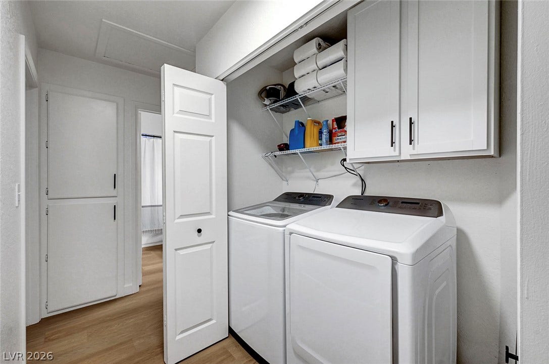 Functional utility space features warm wood-look flooring and built-in storage solutions.