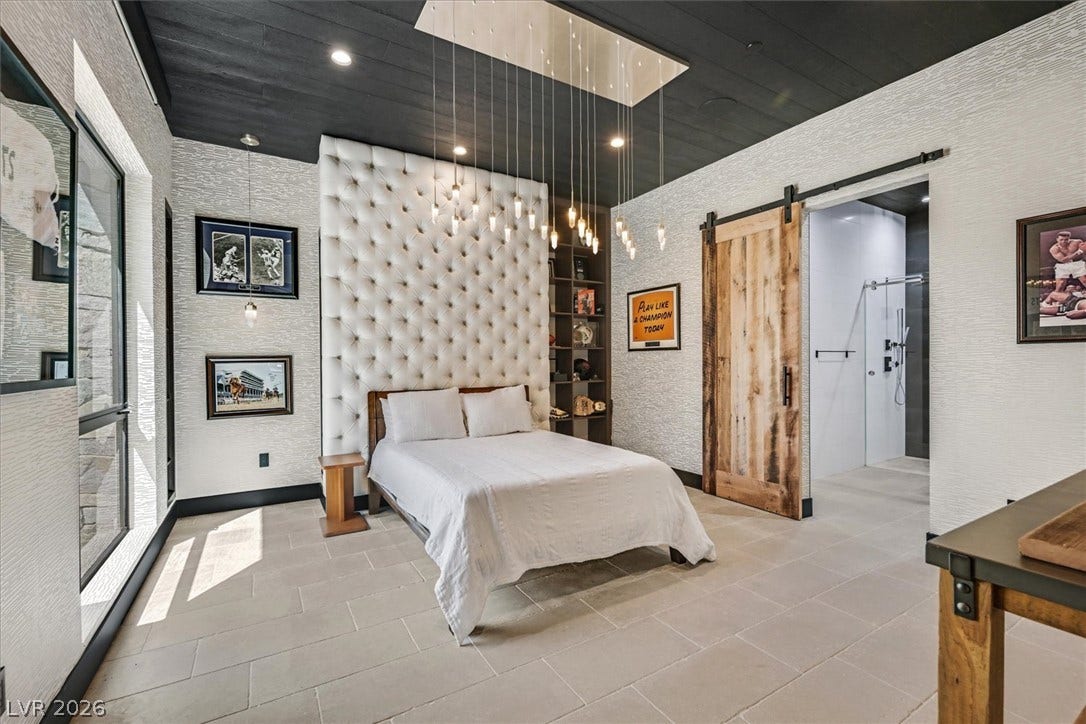 4155 Badura Avenue, Las Vegas, NV 89118 A dark paneled ceiling and stone tile flooring define this modern, comfortable bedroom suite.