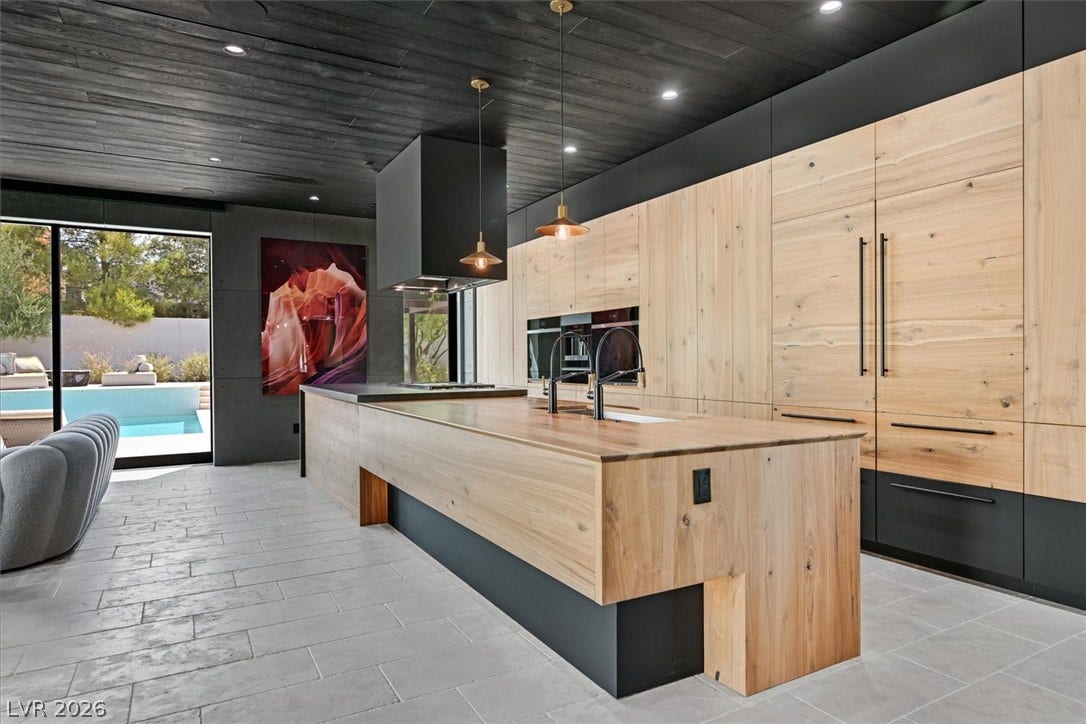 4155 Badura Avenue, Las Vegas, NV 89118 Rich wood ceilings and custom cabinetry define this architectural kitchen opening to the patio.