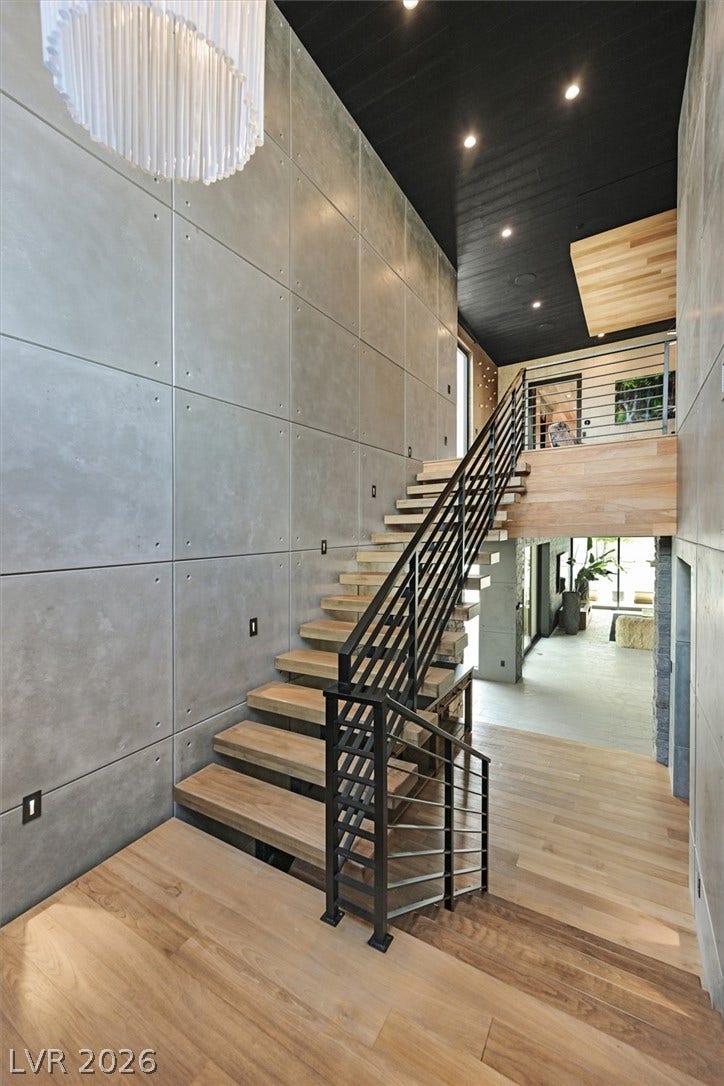 4155 Badura Avenue, Las Vegas, NV 89118 Concrete panel walls and light wood steps create a striking industrial transition between levels.