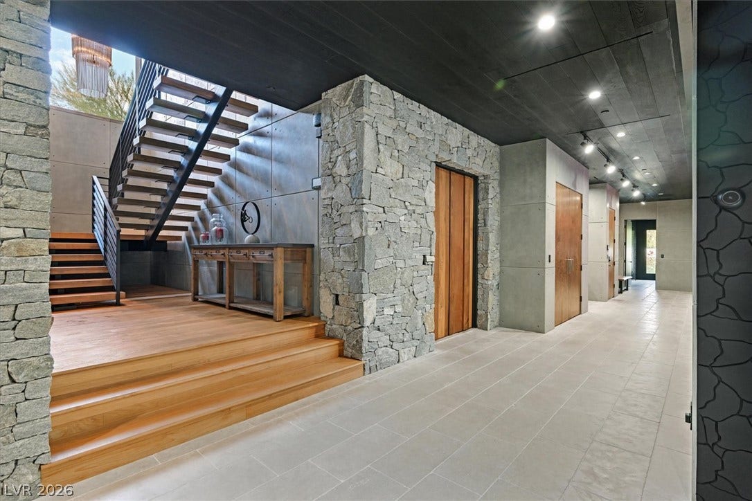 4155 Badura Avenue, Las Vegas, NV 89118 Dramatic stone accents, custom wood steps, and sleek architectural lines define this welcoming entryway.