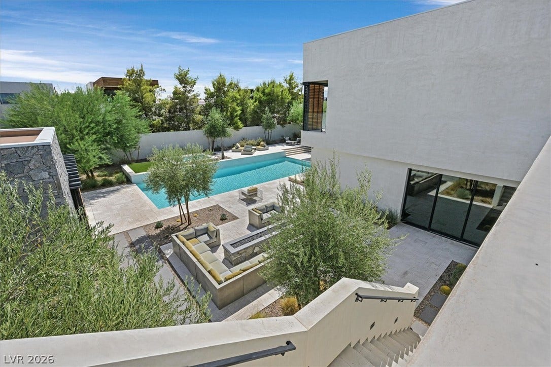 4155 Badura Avenue, Las Vegas, NV 89118 A spacious backyard oasis features a modern pool alongside an elegant stone-paved patio area.