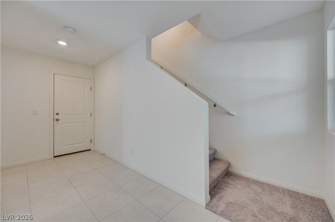 Tiled flooring and carpeted stairs define this welcoming entryway.