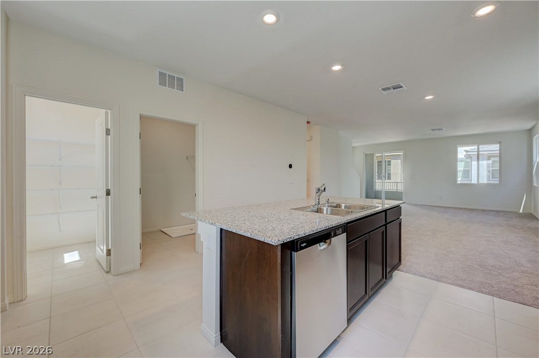 An open floorplan seamlessly connects the kitchen island to the adjoining living space.