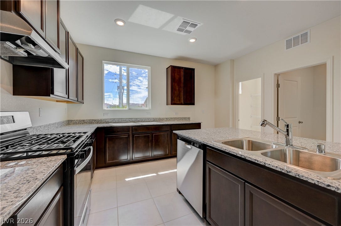 Rich dark cabinetry pairs beautifully with stone countertops and stainless steel appliances.