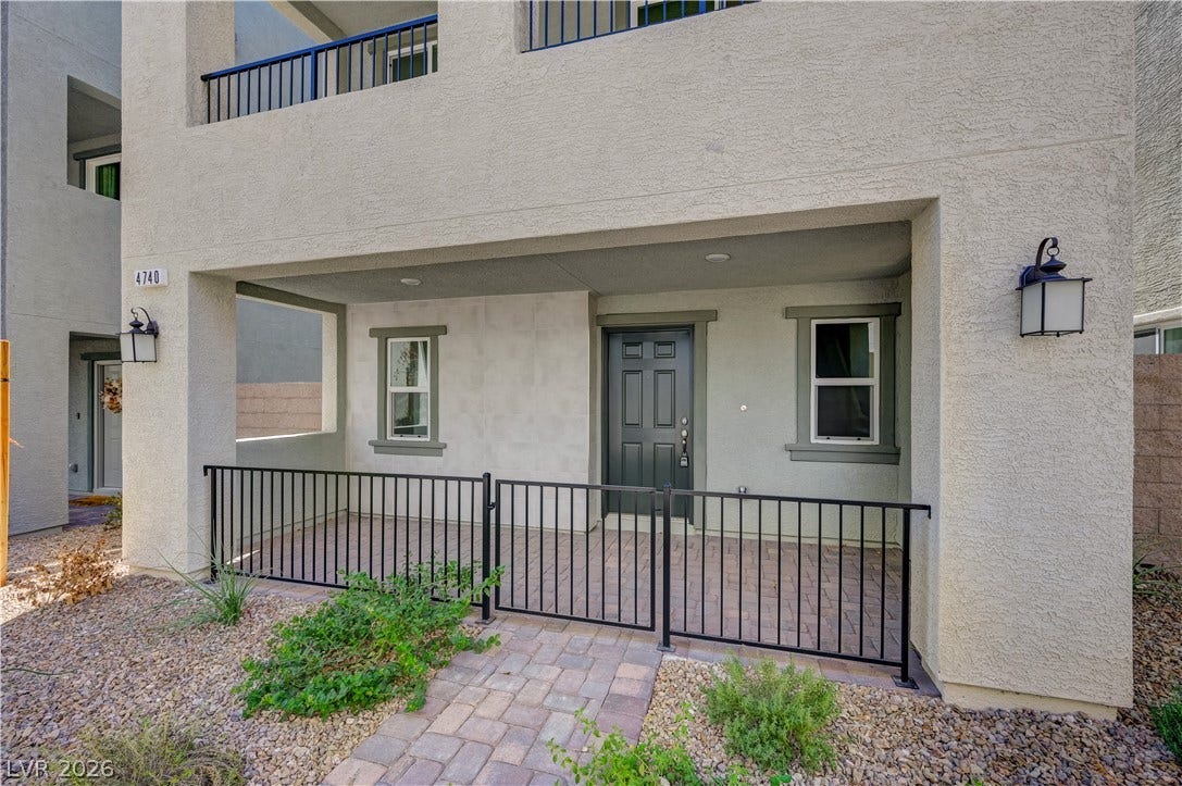 An inviting gated courtyard and paved walkway lead directly to the main entry.