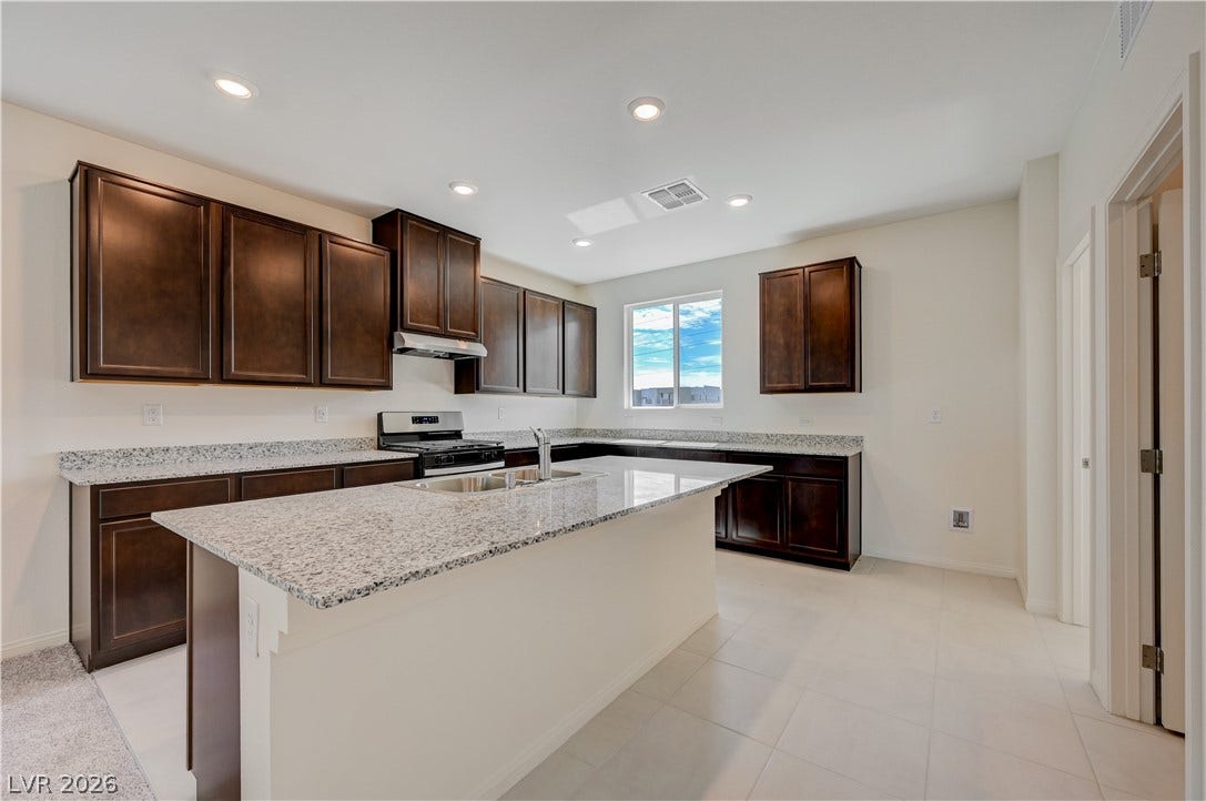 Rich dark wood cabinets contrast beautifully with light stone countertops in this modern kitchen.