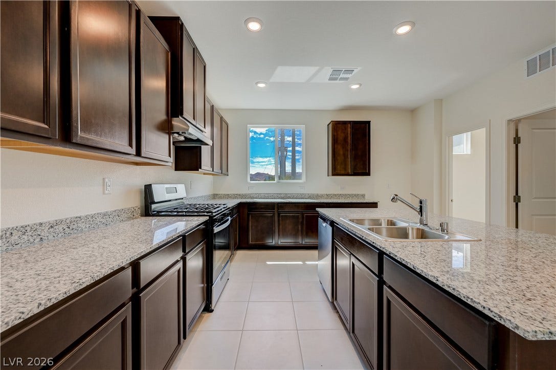 Rich dark cabinetry pairs beautifully with speckled granite countertops in this modern kitchen layout.