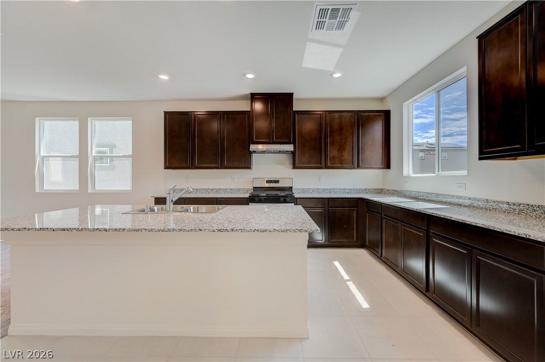 Gleaming stone countertops and rich cabinetry define this modern culinary space.