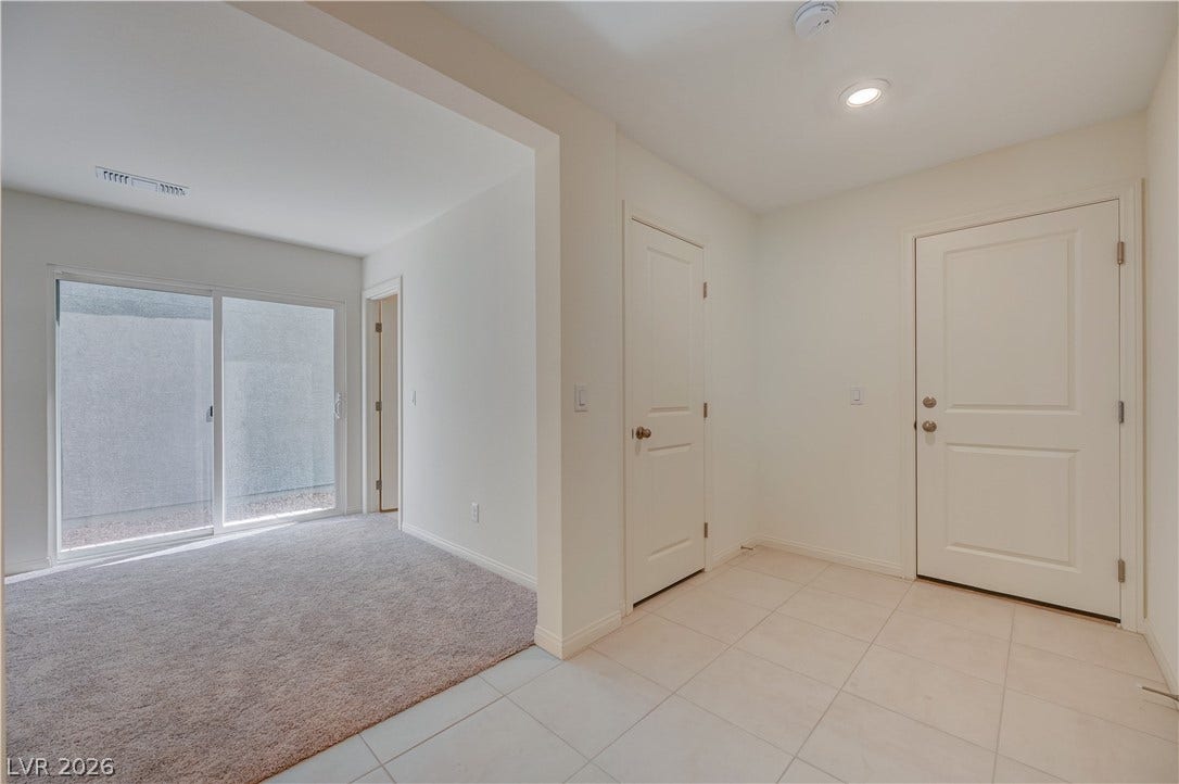 Tiled flooring transitions seamlessly to carpeted living space beneath recessed lighting.